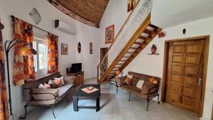 uma sala de estar com uma escada, cadeiras e uma mesa em Safari Village - Case73 em Saly Portudal