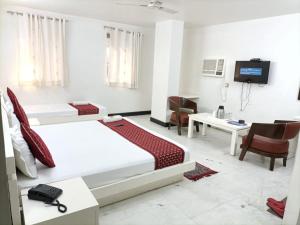 a hotel room with two beds and a desk at Hotel Sweet Home Near New Delhi Railway Station in New Delhi