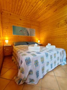 una camera da letto con letto in una camera in legno di Summer Paradise a Capitello (Ispani)