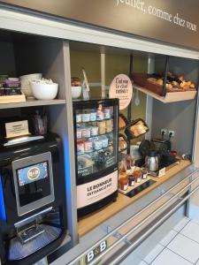 um balcão de padaria com frigorífico e alguma comida em B&B HOTEL Rennes Ouest Villejean em Rennes