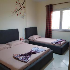 Habitación con 2 camas y ventana en Relax Apartments Golem, en Golem