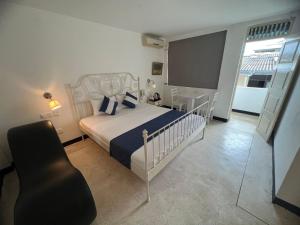 ein Schlafzimmer mit einem Bett und einem Stuhl darin in der Unterkunft Beverly Villa in Colombo