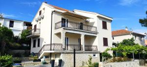 a white building with balconies on the side of it at Vila Beleca Krk - Apartments Rest & Sea in Krk