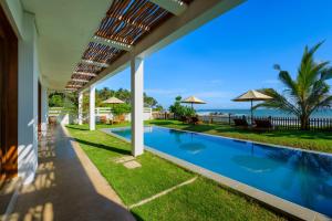 an image of a house with a swimming pool and the ocean at Villa Tanderra in Tangalle