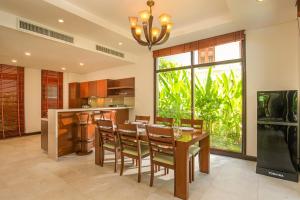 ダナンにあるDa Nang Beach Villa Resortのテーブルと椅子のあるキッチンとダイニングルーム