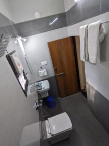 a bathroom with a white toilet and a sink at Erisha Tadoba in Mohurli
