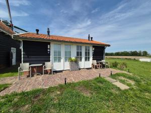 a house with a patio and a table and chairs at Landelijk slapen bij molen in Ovezande 4C in Ovezande