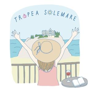 特羅佩阿的住宿－Tropea Solemare，戴帽子和一杯葡萄酒的女孩,欣赏海景