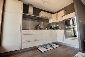 a kitchen with white cabinets and a sink at ANNEMASSE - VICTORIA Centre ville, Grand T2 avec Terrasse in Annemasse
