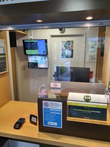a store with a cash register and a phone on a counter at B&B HOTEL Rennes Ouest Villejean in Rennes