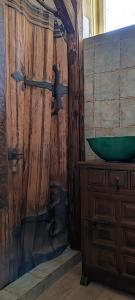 Napsugár Apartman في أبادزالوك: حمام مع حوض أخضر على جدار خشبي