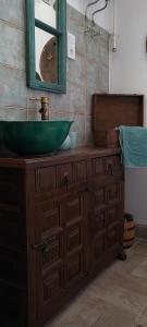 baño con lavabo verde y espejo en Napsugár Apartman, en Abádszalók