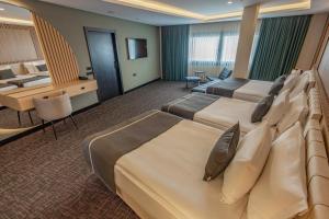 a hotel room with two beds and a desk at FT Lotus Thermal Hotel&SPA Trademark Collection by Wyndham in Menemen