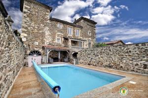 a swimming pool in front of a stone building at Gite du Chateau in Éclassan