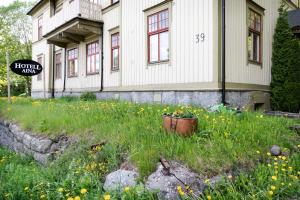 a house with a field of flowers in front of it at Hotell Aina in Kvissleby