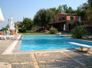 a swimming pool with a bench and a house at Fundana Villas in Liapades