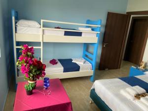 路克維的住宿－Selami Sea View Apartments，客房设有两张双层床和一张带鲜花的桌子。