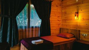a bed in a wooden room with a window at Sheriff, Olympos in Kumluca
