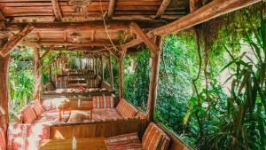 an outdoor room with couches and tables and trees at Sheriff, Olympos in Kumluca