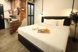 1 dormitorio con 1 cama con libro y lavamanos en Suite 18 Boutique Hotel en Kuala Terengganu