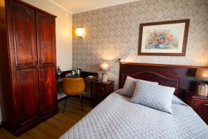 a bedroom with a bed and a desk with a chair at Hotel Legend in Pärnu