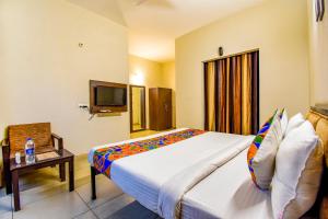 Habitación de hotel con cama grande y TV en FabHotel G-5 Villa, en Ludhiana