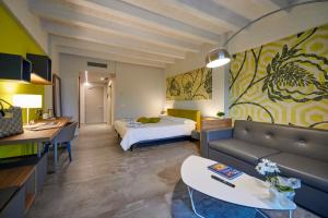 Habitación de hotel con cama y sala de estar. en Ca' Barbini Resort en Garda