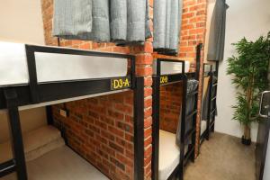 a room with two bunk beds against a brick wall at Suite 18 Boutique Hotel in Kuala Terengganu