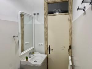 y baño con lavabo y espejo. en Apartamentos Los Patios de la Judería, en Córdoba