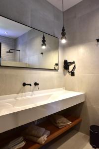 ein Badezimmer mit einem weißen Waschbecken und einem Spiegel in der Unterkunft Rafael Hotel-Adults Only in Lindos