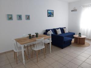 sala de estar con sofá azul, mesa y sillas en Kasi's nature home en Kýthira