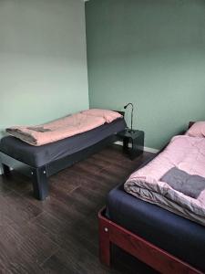 2 łóżka pojedyncze w pokoju ze ścianą w obiekcie Residence Sanne w mieście Breda
