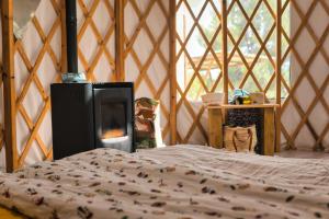 a bedroom with a bed and a fireplace in a yurt at La Muntanera - Eco Yurt - Pool, Nature retreat in Figuerola