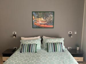 a bedroom with a bed with pillows and a painting at B&B Residence Armonia Sulmona in Sulmona