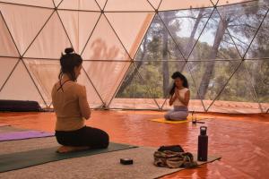 two women sitting in a tent in the water at La Muntanera - Eco Yurt - Pool, Nature retreat in Figuerola +27 photos