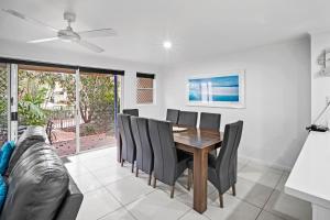 a dining room with a table and chairs and a couch at Diamond Beach 35 in Gold Coast