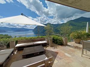 a patio with a table and an umbrella at IseoLakeRental - La Dolce Vista in Riva di Solto