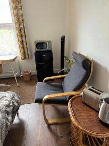 ein Wohnzimmer mit einem Stuhl und einem Tisch in der Unterkunft Rectory Cottage in Croydon