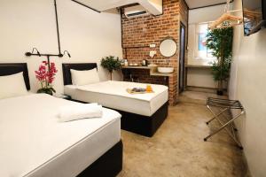 a room with two beds and a bathroom with a mirror at Suite 18 Boutique Hotel in Kuala Terengganu