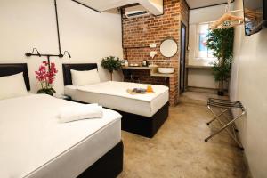 a room with two beds and a bathroom with a mirror at Suite 18 Boutique Hotel in Kuala Terengganu
