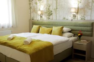 a bedroom with a large bed with towels on it at Szalajka Liget Hotel és Apartmanházak in Szilvásvárad