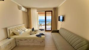 a hotel room with a bed and a couch at Апартаменти и студия в комплекс Акротирия in Nesebar