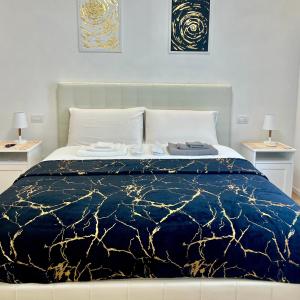 Schlafzimmer mit einem Bett mit einer blauen und goldenen Bettdecke in der Unterkunft Angels apartment in Bari