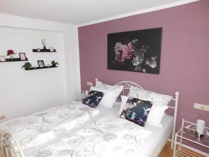 ヴィットリッヒにあるFEWO Trautの紫の壁の白いベッドが備わるベッドルーム1室