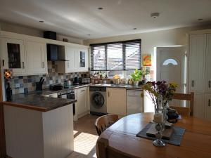 une cuisine avec une table en bois et une salle à manger dans l'établissement Fell View House, à Kendal