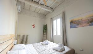 a bedroom with a bed with white sheets and a window at Stazione - Arno River apartment in Florence