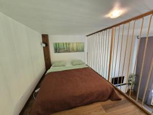 a small bedroom with a bed in a room at Loft Apartment in Klaipėda