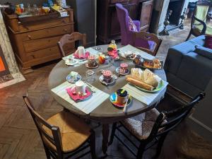 a table with food on it in a living room at La belle histoire à Roubaix in Roubaix