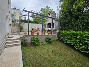 a garden with a stone oven in a building at Palme Apartments in Opatija
