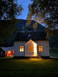 een wit huis met de lichten aan 's nachts bij Hagusane Feriehus in Lærdalsøyri